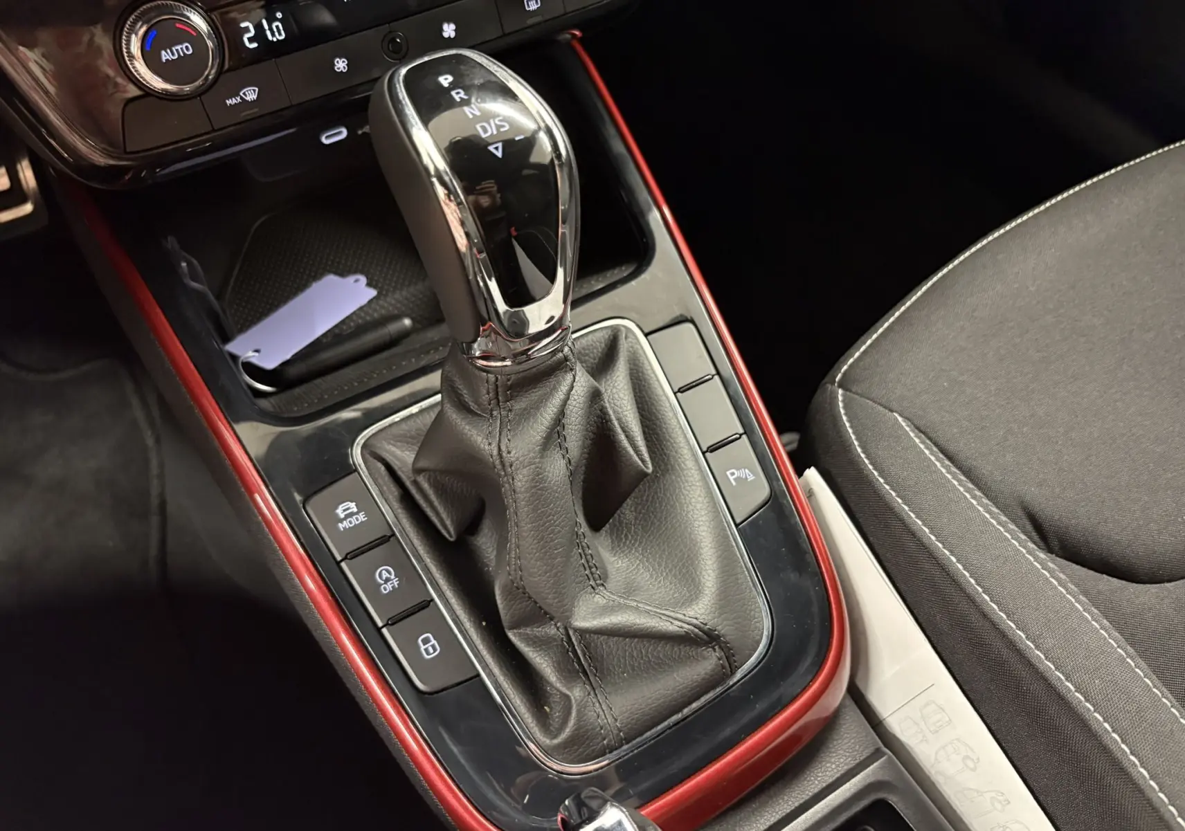 Gros plan sur la console centrale de la Skoda Fabia 1.0 TSI 116 DSG7 Monte Carlo, levier de vitesse automatique et sellerie noire.
