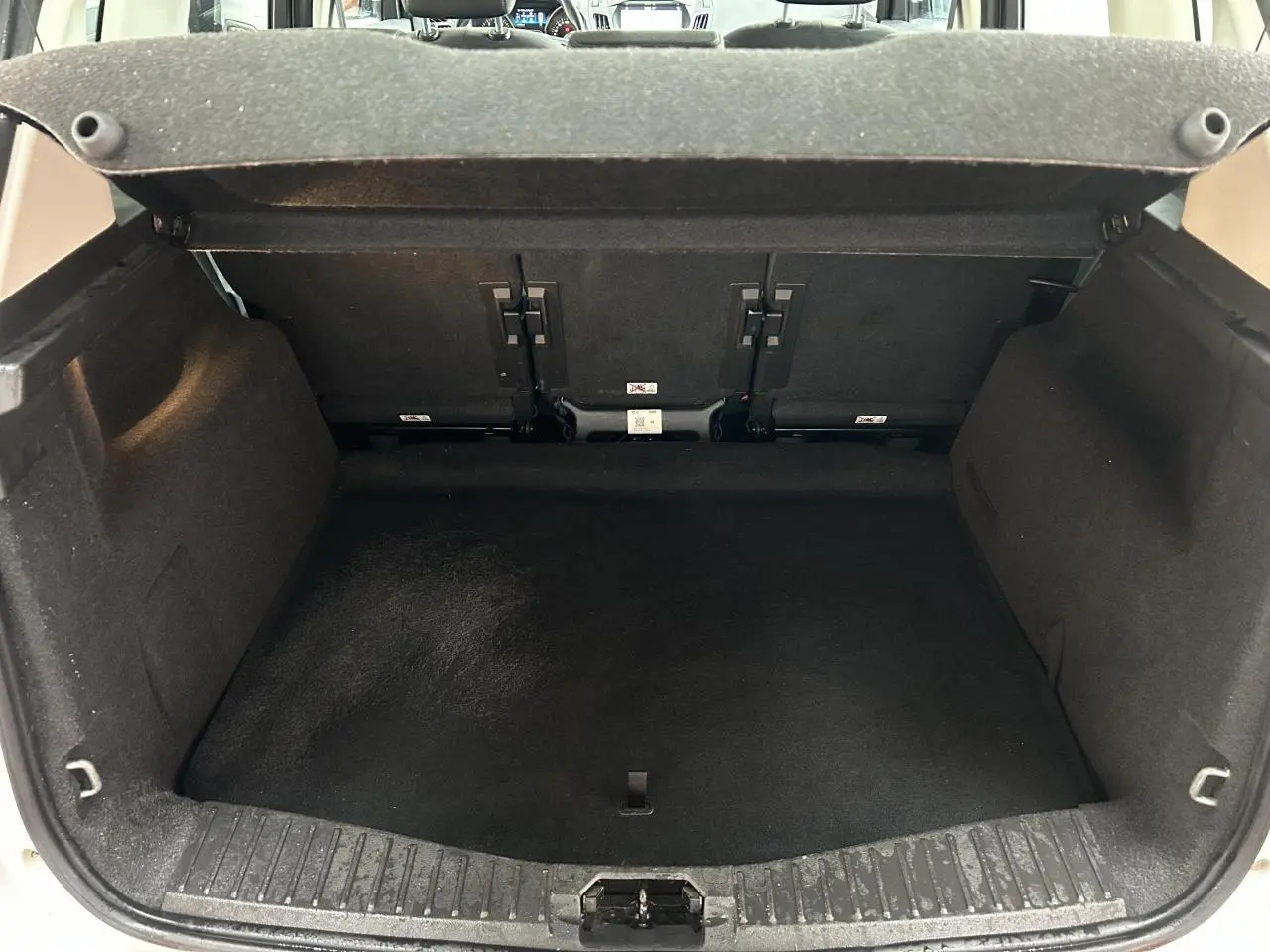 Coffre ouvert d'une Ford C-MAX blanc 2018, vue de l'arrière montrant l'espace de chargement vide.