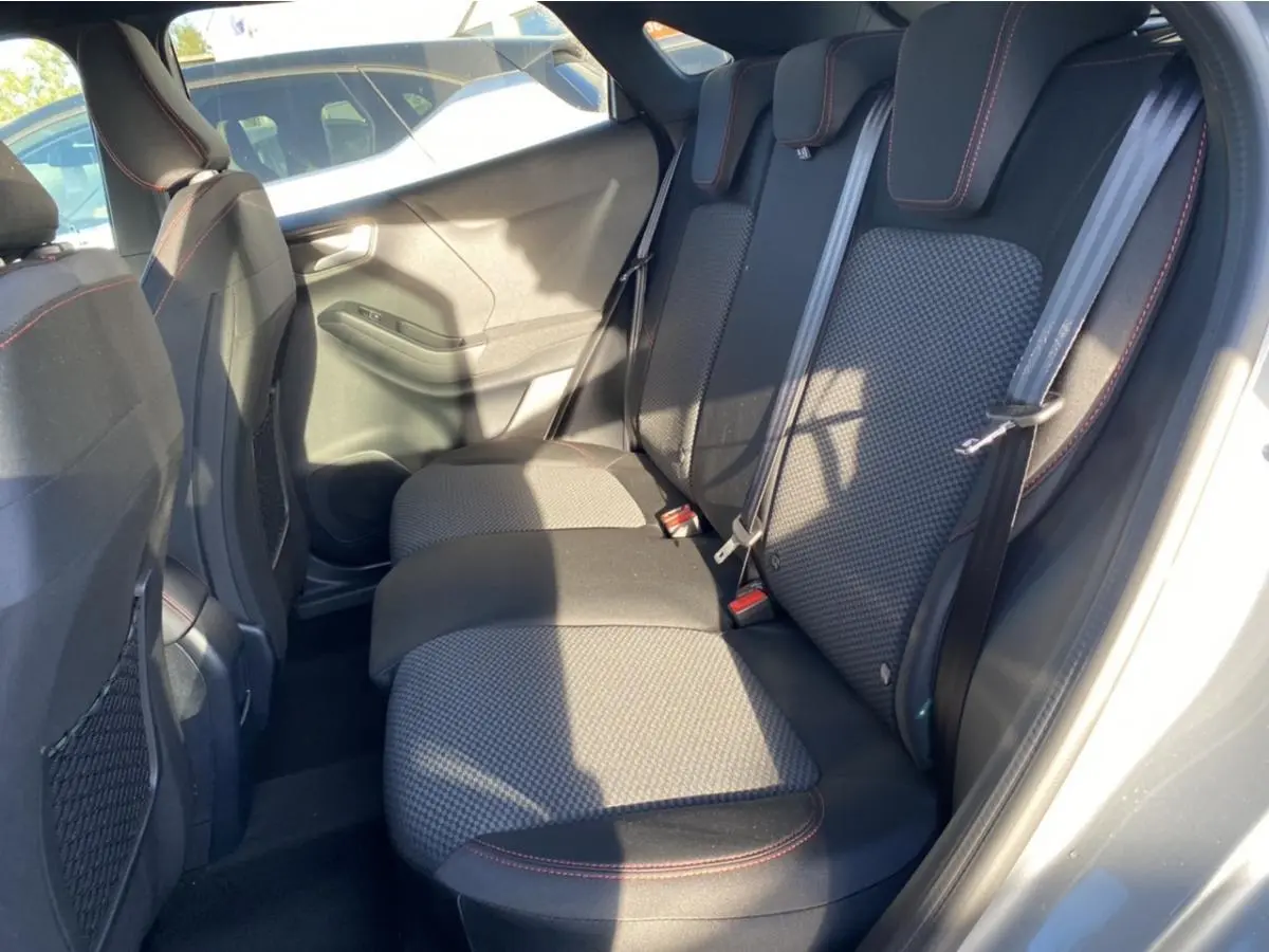 Banquette arrière en tissu gris avec surpiqûres rouges du Ford Puma gris, vue depuis la porte arrière droite ouverte.