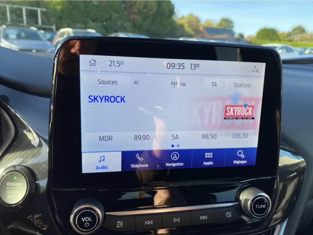 Écran tactile central du Ford Puma 2021 affichant la radio Skyrock avec commandes audio et bouton start/stop à gauche.