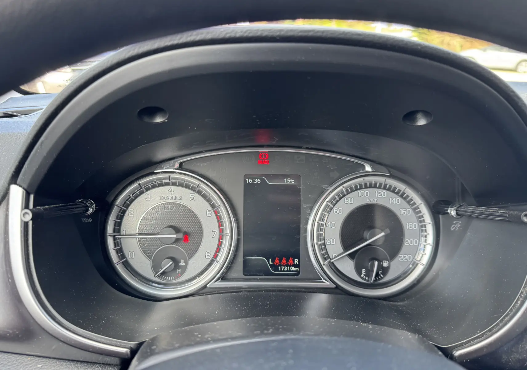 Vue rapprochée du tableau de bord du Suzuki Vitara blanc 2023, affichant compte-tours, vitesse et indicateurs numériques.