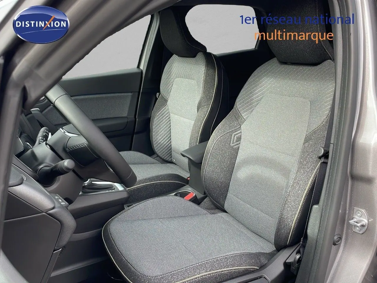 Intérieur du Renault Captur E-Tech hybride 2025, vue côté conducteur, sièges tissu gris et noir, tableau de bord partiel visible.