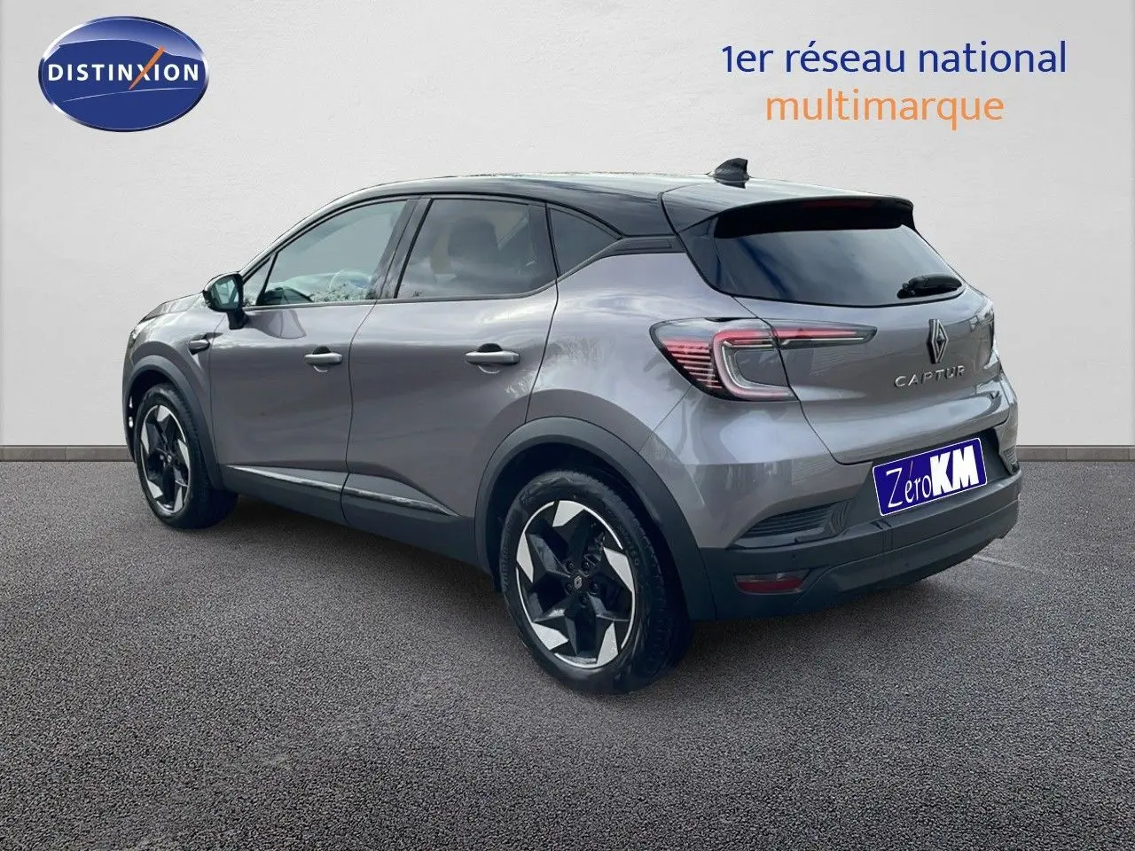 Renault Captur E-Tech hybride gris cassiopée métal avec toit noir, vue 3/4 arrière côté gauche, jantes stylées noires et argentées.