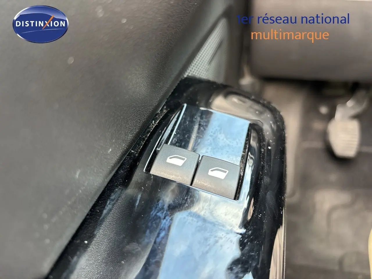Gros plan sur les boutons de commande des vitres électriques côté conducteur d'une Citroën C3 blanche banquise de 2022.