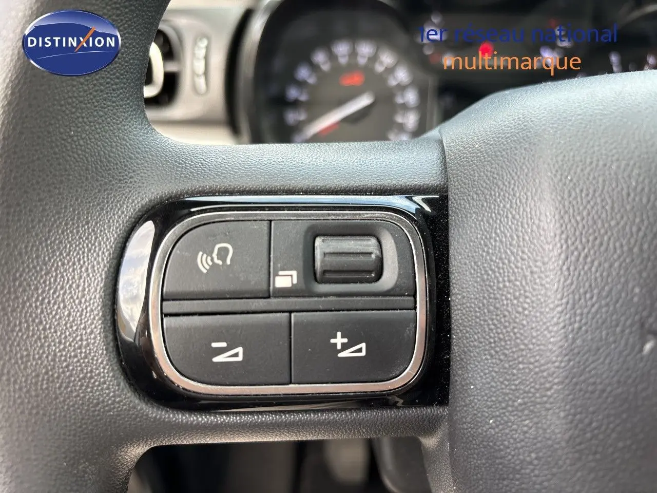 Gros plan sur les commandes de volume et téléphone intégrées au volant d'une Citroën C3 blanche banquise, 2022.