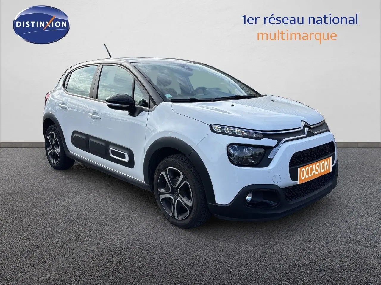 Citroën C3 blanc banquise vue 3/4 avant droit avec protections latérales noires et jantes stylisées.