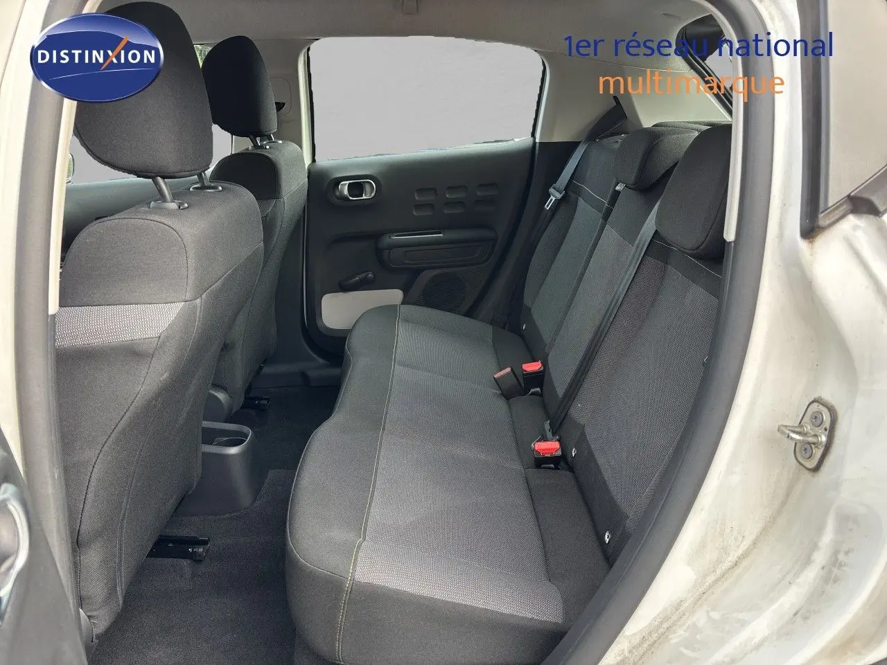 Vue intérieure arrière côté droit de la Citroën C3 blanc banquise, montrant la banquette arrière en tissu gris.