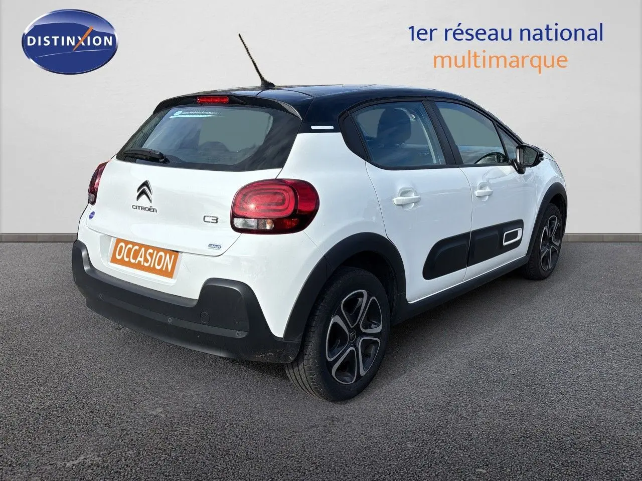 Vue 3/4 arrière droite d'une Citroën C3 blanche banquise avec toit noir et protections latérales noires.