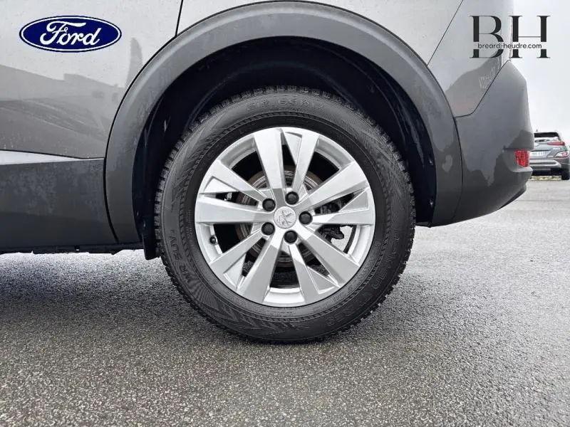 Gros plan sur la roue arrière droite d’un Peugeot 5008 gris Platinium, avec jante alu au design moderne.