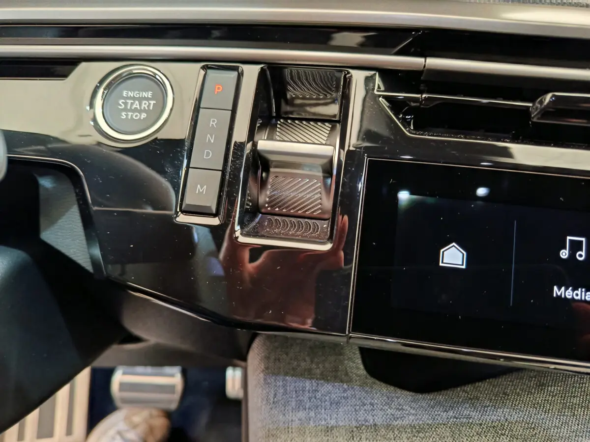 Détail intérieur du tableau de bord noir brillant du Peugeot 3008 1.2 Hybrid 145 GT avec bouton start/stop et commandes de boîte automatique.