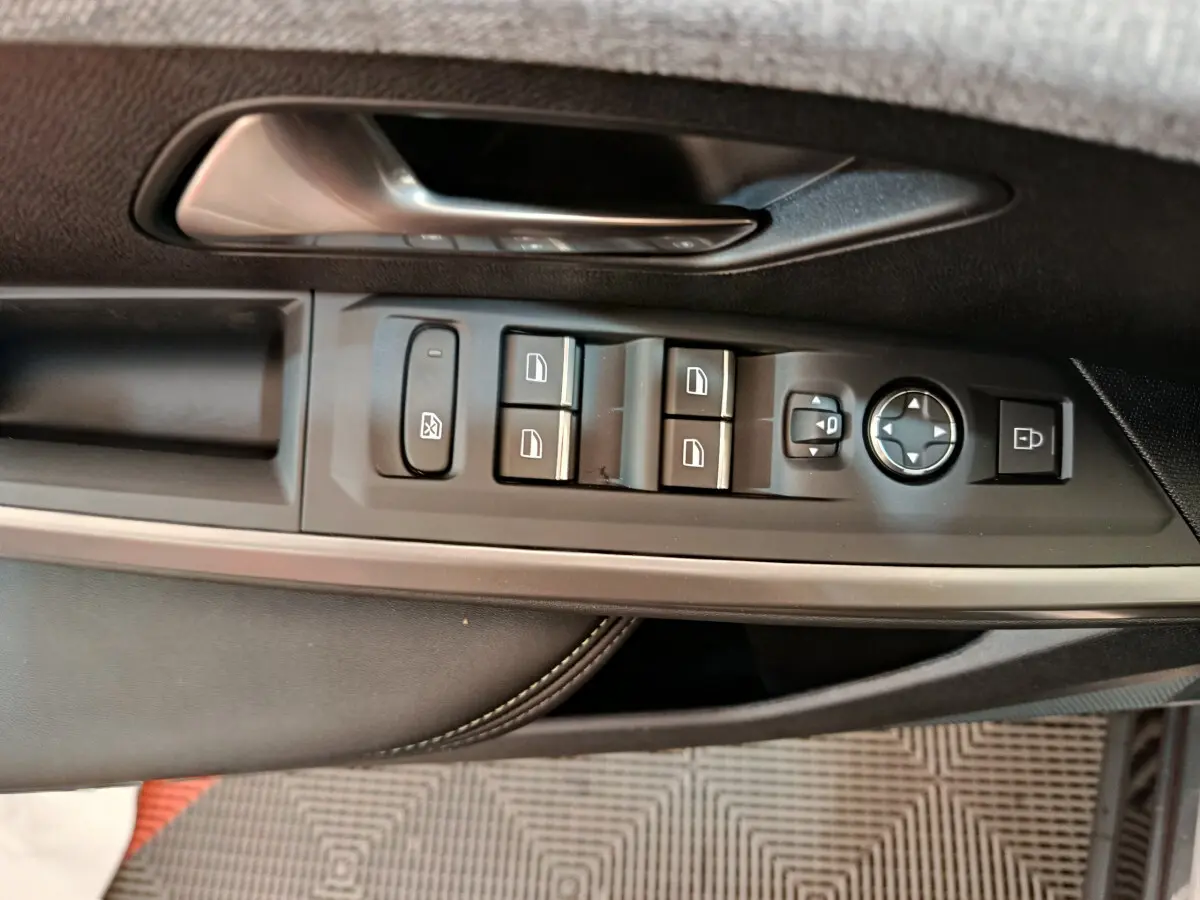 Détail des commandes de lève-vitres et rétroviseurs sur la porte côté conducteur d’un Peugeot 3008 noir 2025.