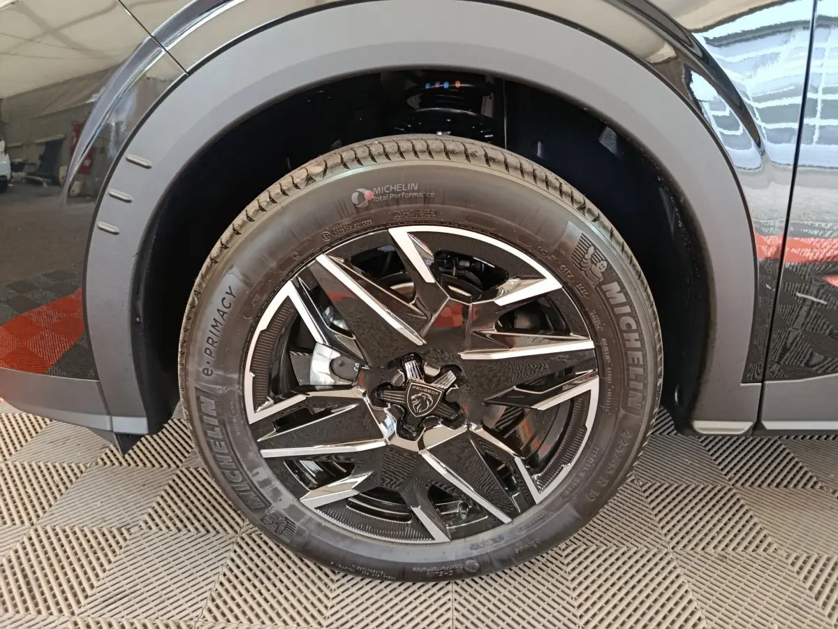 Gros plan sur la roue avant gauche noire du Peugeot 3008 1.2 Hybrid 145 GT avec jante alliage bicolore et pneu Michelin.