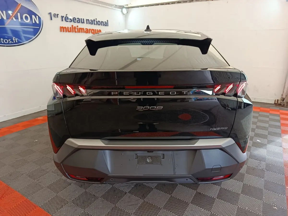 Vue arrière d’un Peugeot 3008 hybride noir 2025 avec feux LED distinctifs et logo central lumineux.