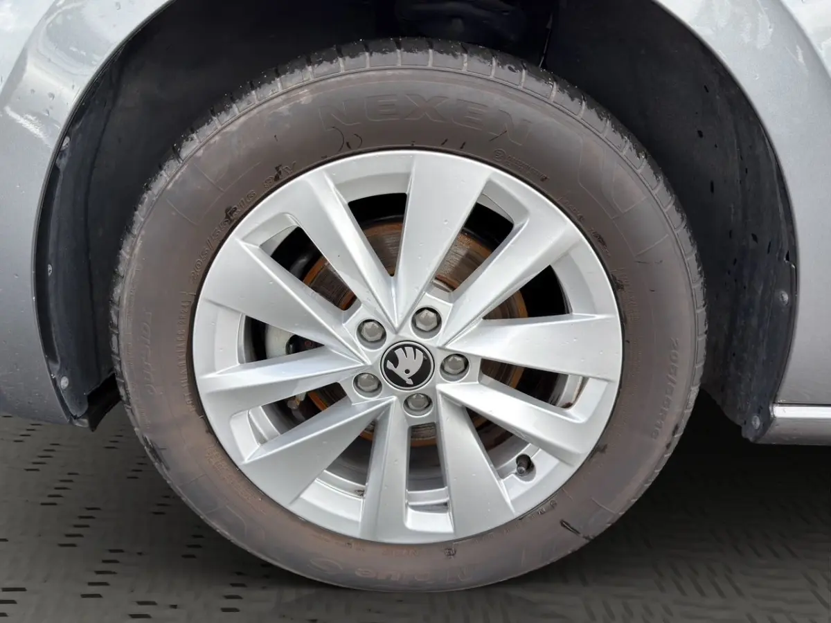 Gros plan sur la roue avant gauche grise d’une Skoda Scala 2025 avec jante alliage et logo central noir.