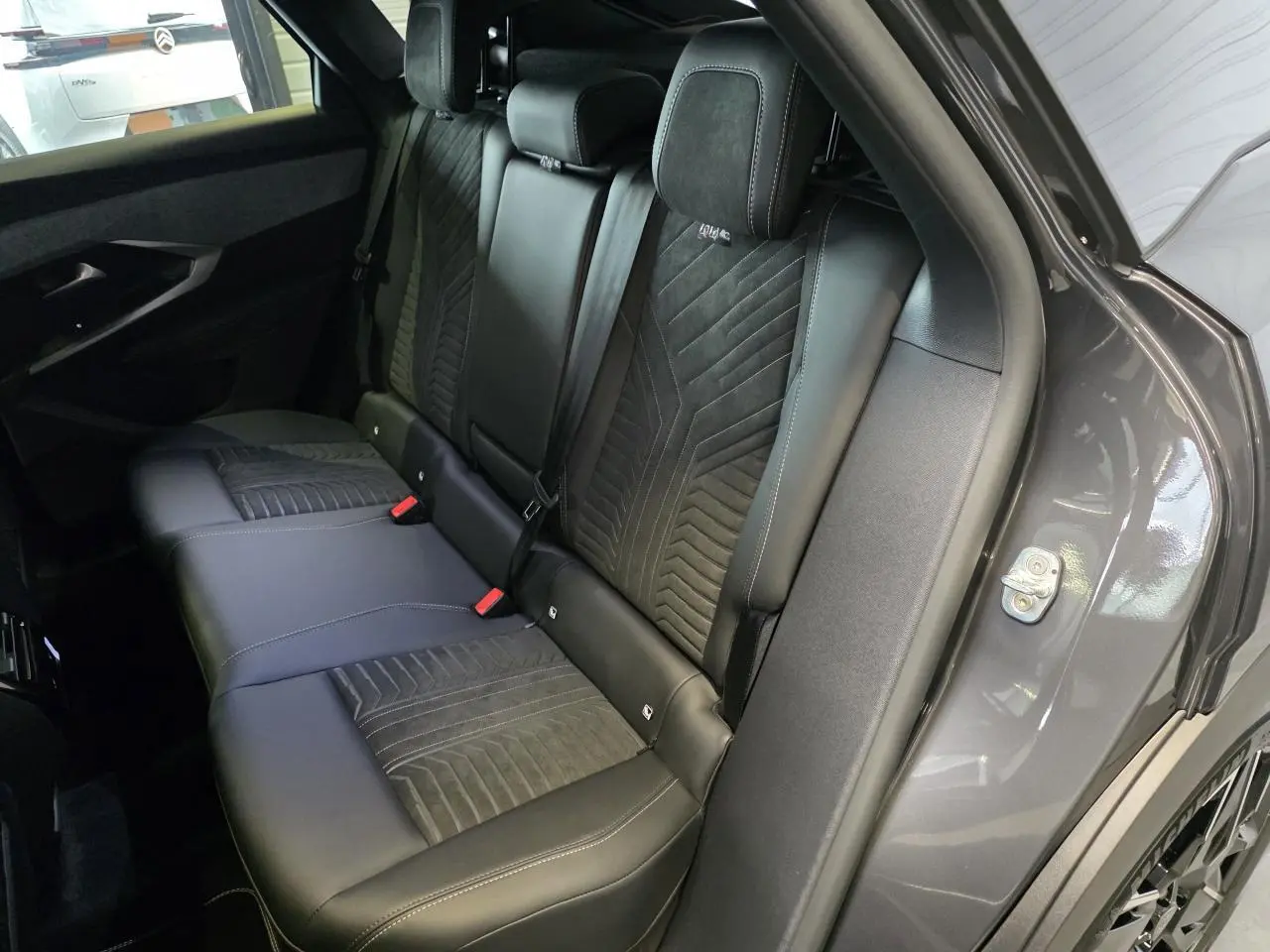 Vue intérieure côté droit des sièges arrière en cuir noir avec surpiqûres du Peugeot 3008 gris titanium 2026 GT Exclusive.