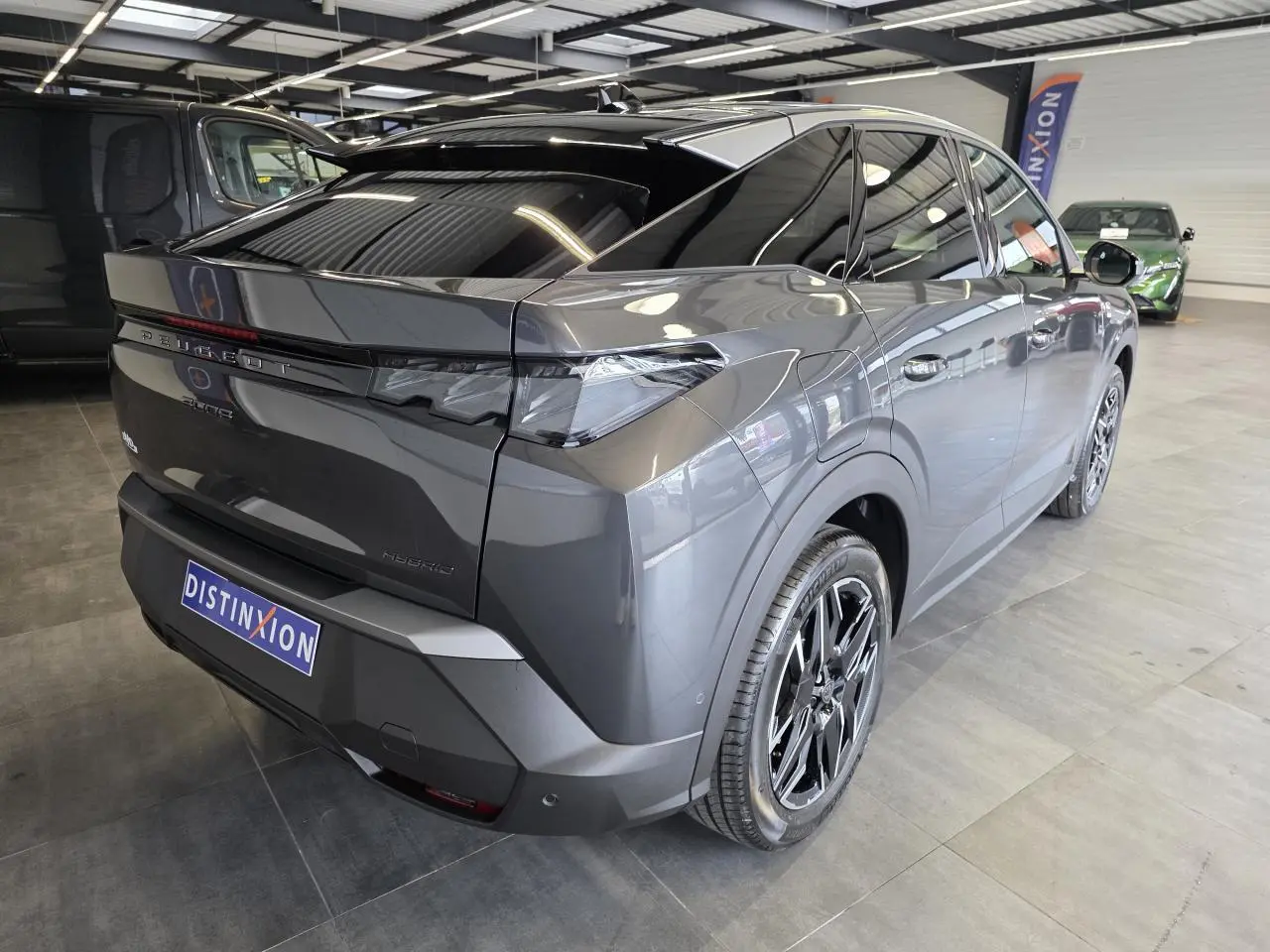Vue 3/4 arrière droite du Peugeot 3008 gris titanium 2026, avec jantes noires et vitres teintées en showroom.
