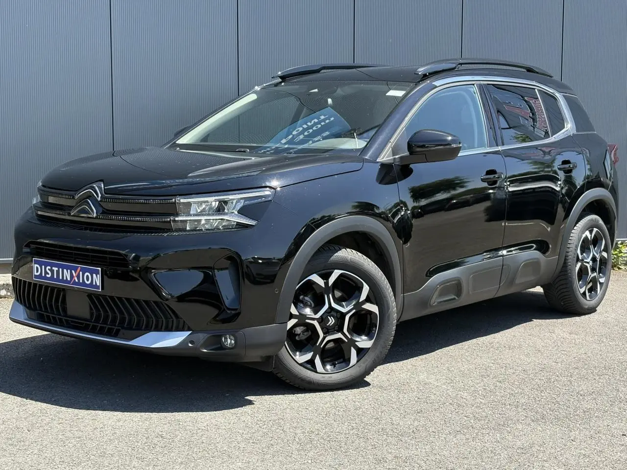 Citroën C5 Aircross Hybrid noir Perla en 3/4 avant droit, avec jantes bi-ton et barres de toit noires.