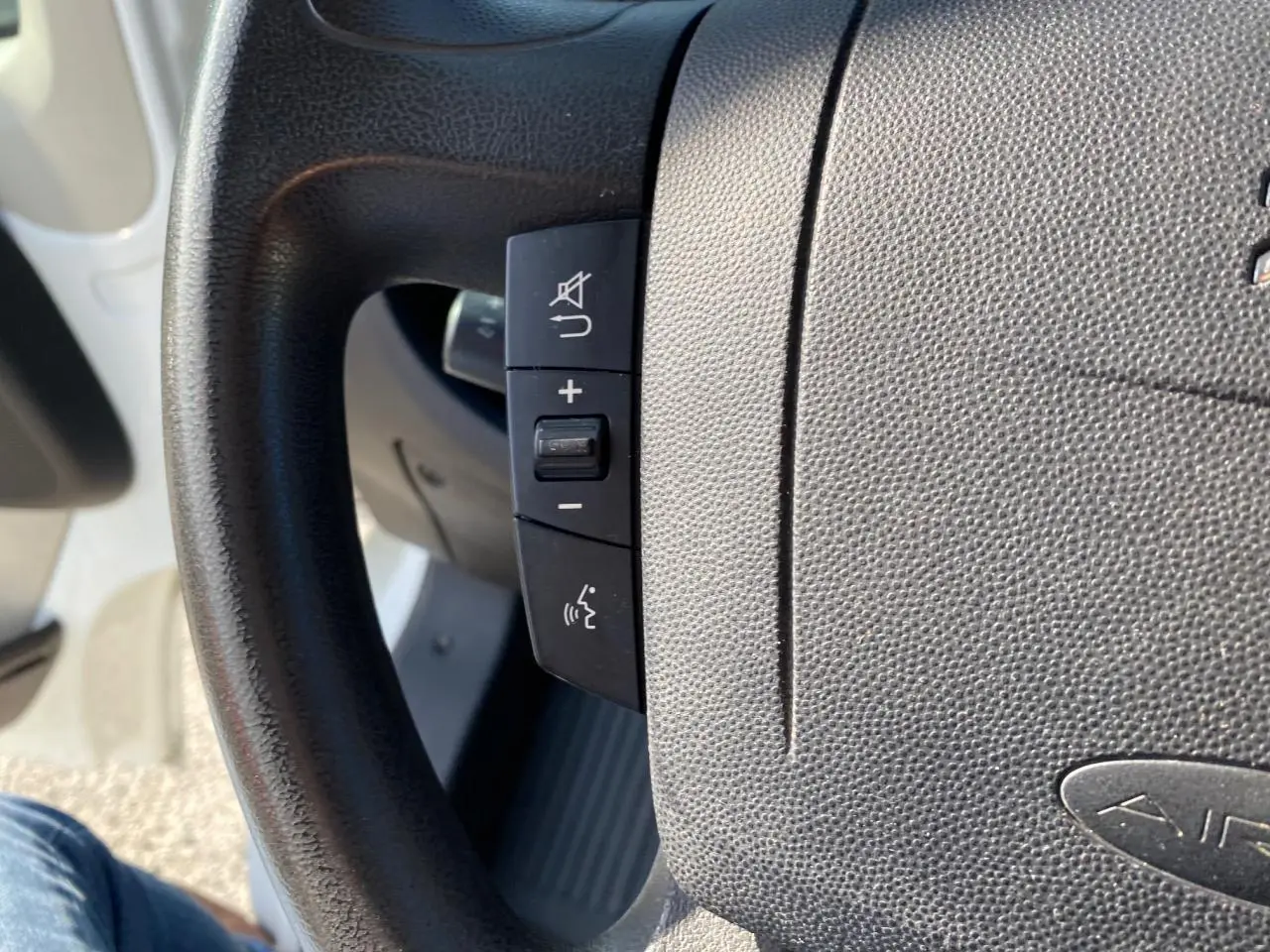 Gros plan sur le volant noir du Citroën Jumper blanc, montrant les commandes audio et téléphone intégrées.