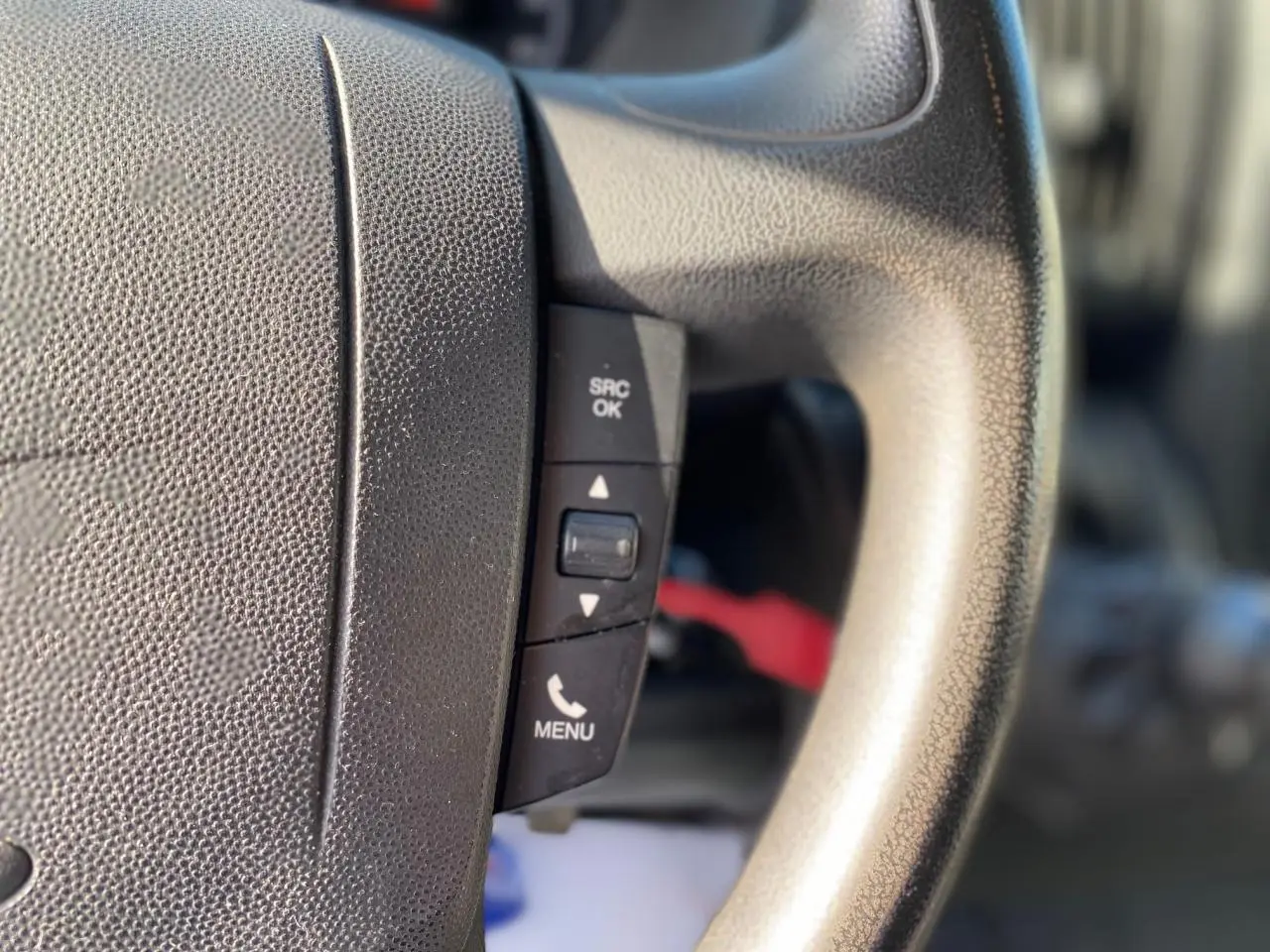 Gros plan sur les commandes du volant du Citroën Jumper blanc 2013, version Confort avec attelage.