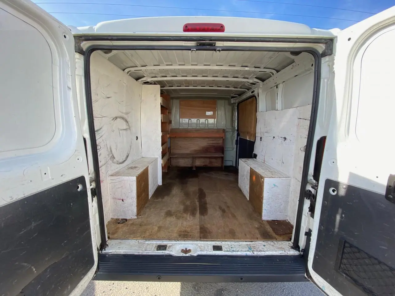 Vue arrière intérieure du Citroën Jumper blanc 2013, fourgon aménagé avec rangements en bois sur les côtés.