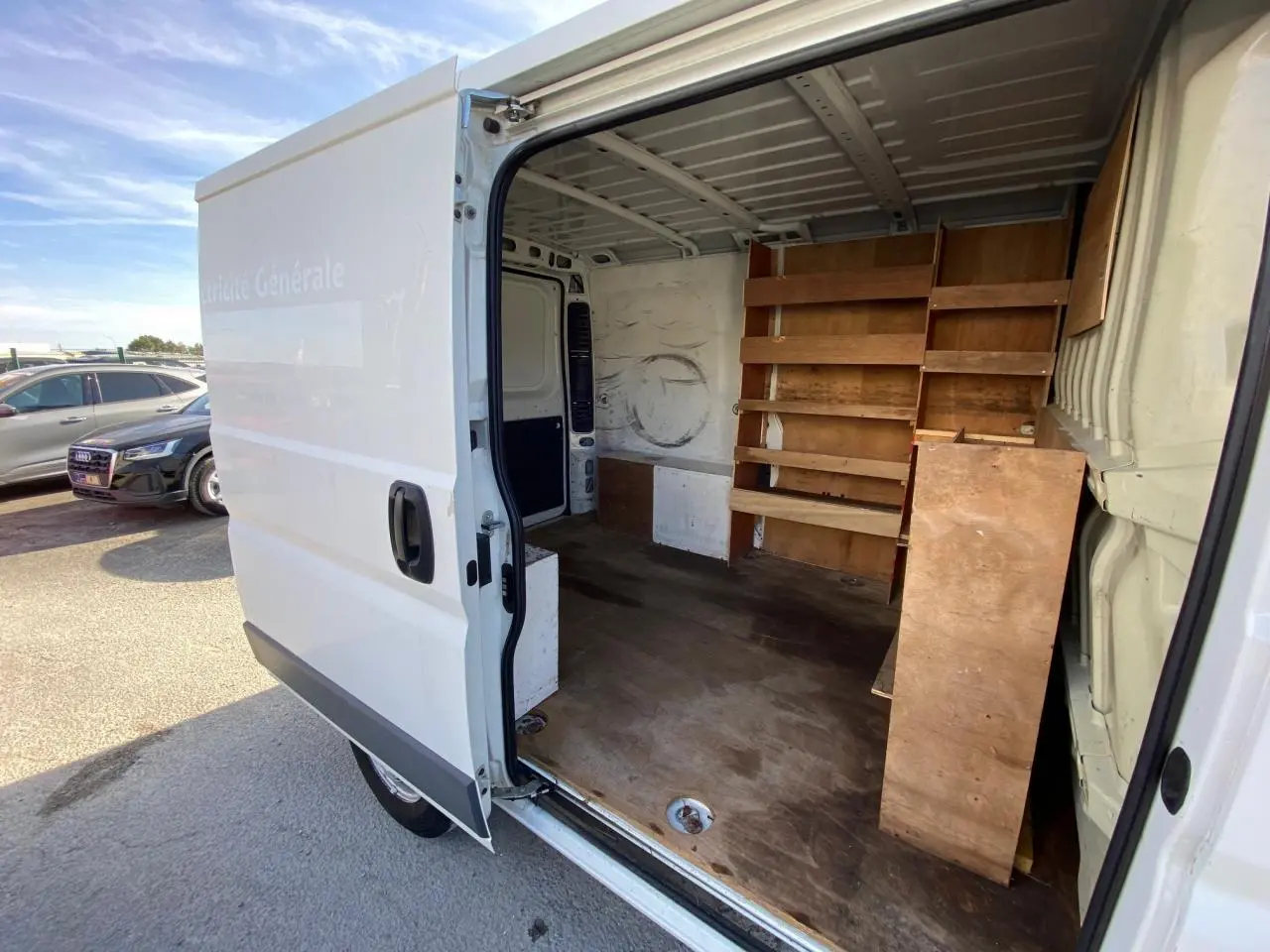 Vue latérale droite du Citroën Jumper blanc 2013 avec porte coulissante ouverte montrant l'intérieur aménagé en fourgon utilitaire.