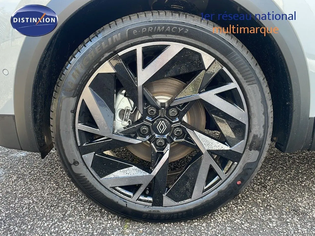 Gros plan sur la jante avant droite noire et argentée du Renault Captur gris Rafale métal avec logo Renault central.