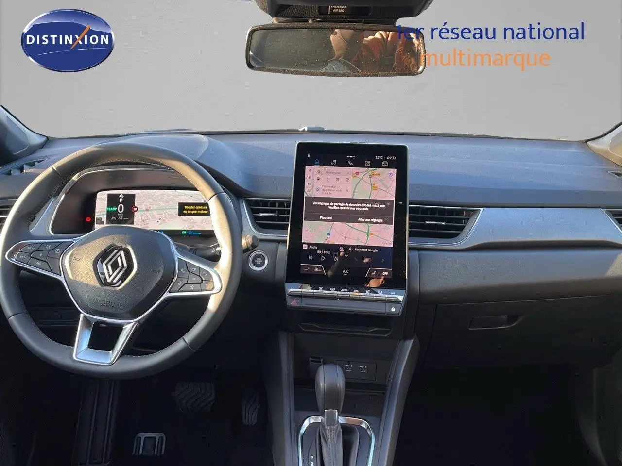 Vue intérieure frontale du tableau de bord du Renault Captur E-Tech Hybrid avec écran tactile vertical et volant multifonction.