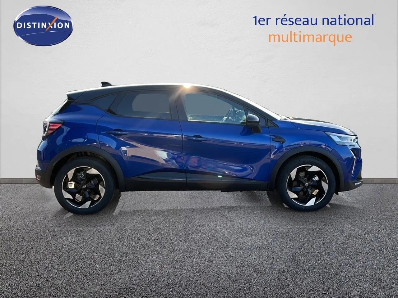 Profil droit du Renault Captur E-Tech hybride bleu Iron Metal avec toit noir et jantes noires distinctives.