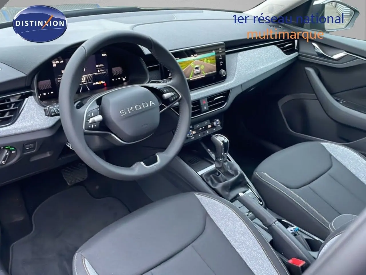 Vue intérieure côté conducteur du Skoda Kamiq gris graphite, montrant le volant, tableau de bord digital et sièges bi-matière.