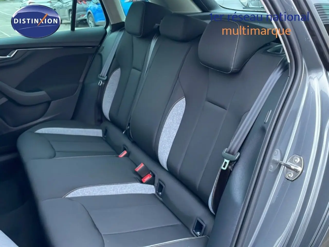 Vue intérieure sur la banquette arrière du Skoda Kamiq gris graphite, avec sellerie tissu noir et inserts gris clair.