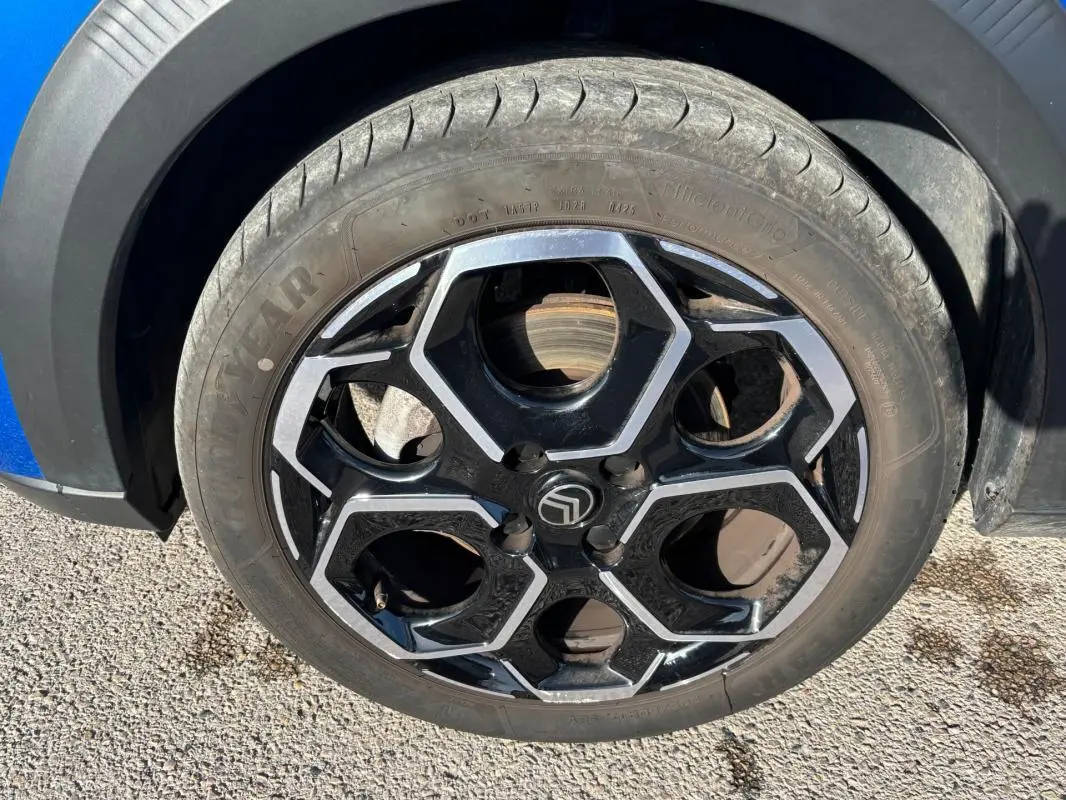 Gros plan sur la jante alliage noire et argentée de 17 pouces d'une Citroën C3 bleu 2025, côté gauche.