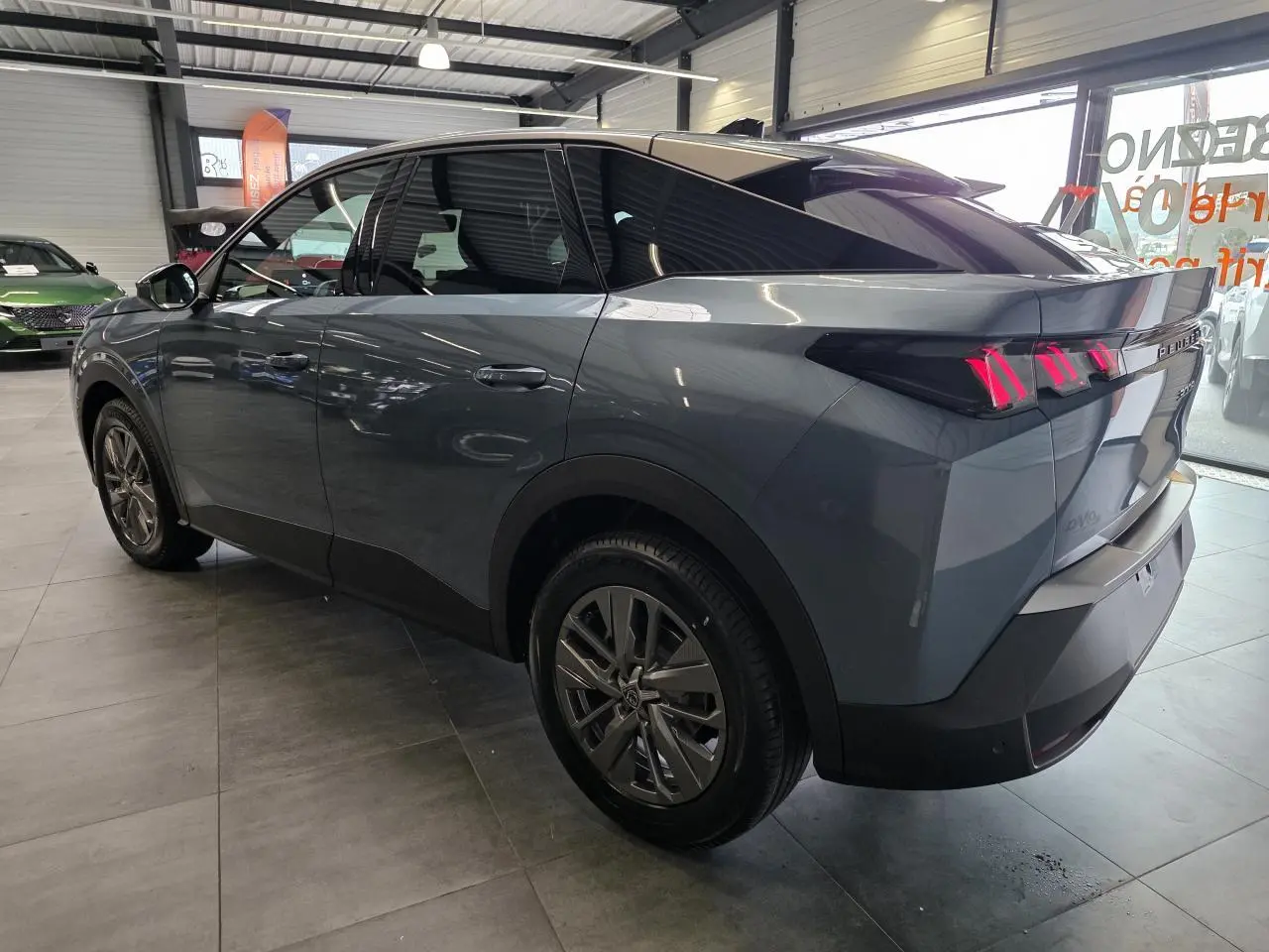 Vue 3/4 arrière droite d’un Peugeot 3008 bleu métallisé avec feux arrière à LED en forme de griffes et jantes alliage 18 pouces.