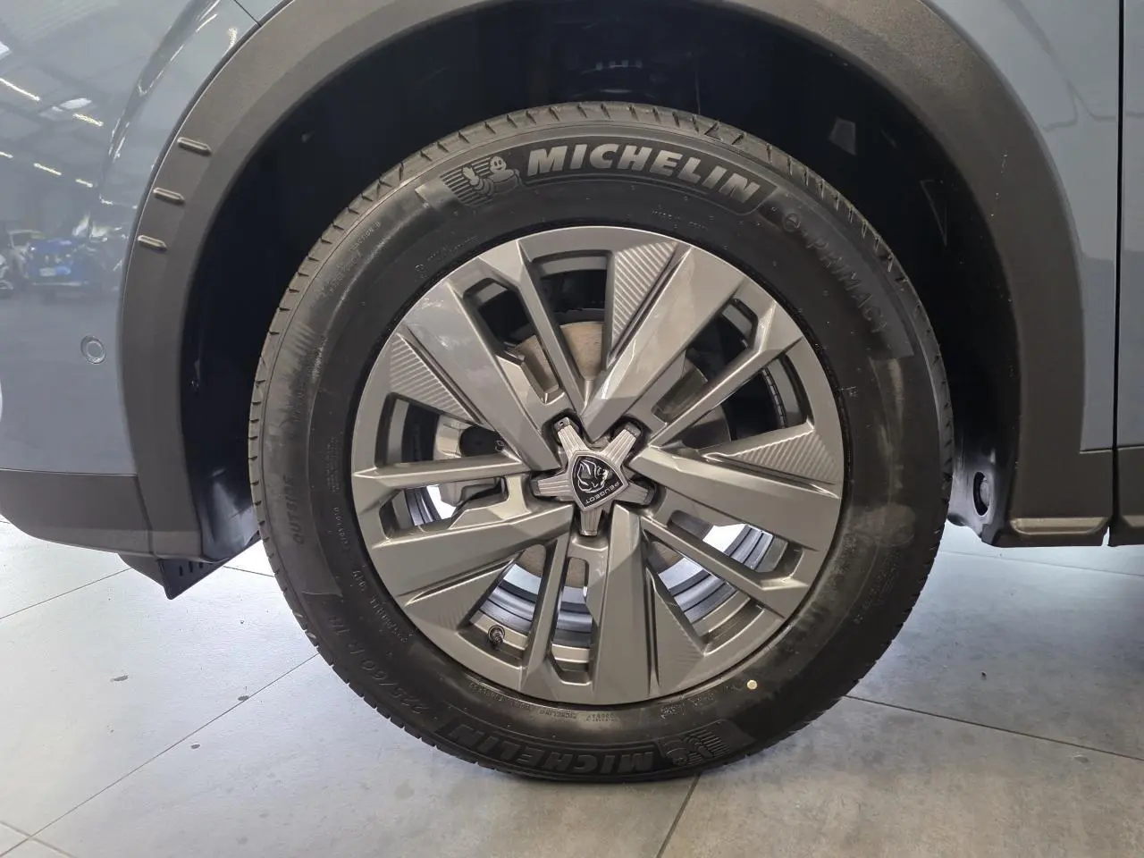 Gros plan sur la roue avant gauche du Peugeot 3008 bleu, avec jante alliage 18'' Basel et pneu Michelin.