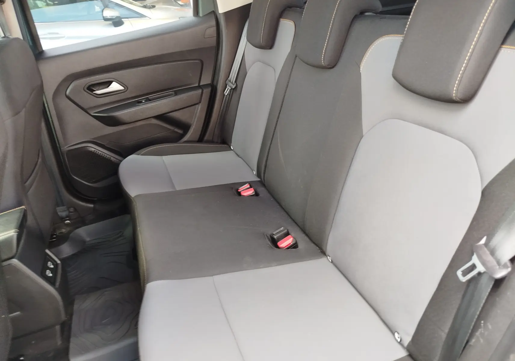 Vue intérieure côté droit des sièges arrière en tissu gris et noir du Dacia Duster 2024, version 1.5 Blue dCi Extreme.