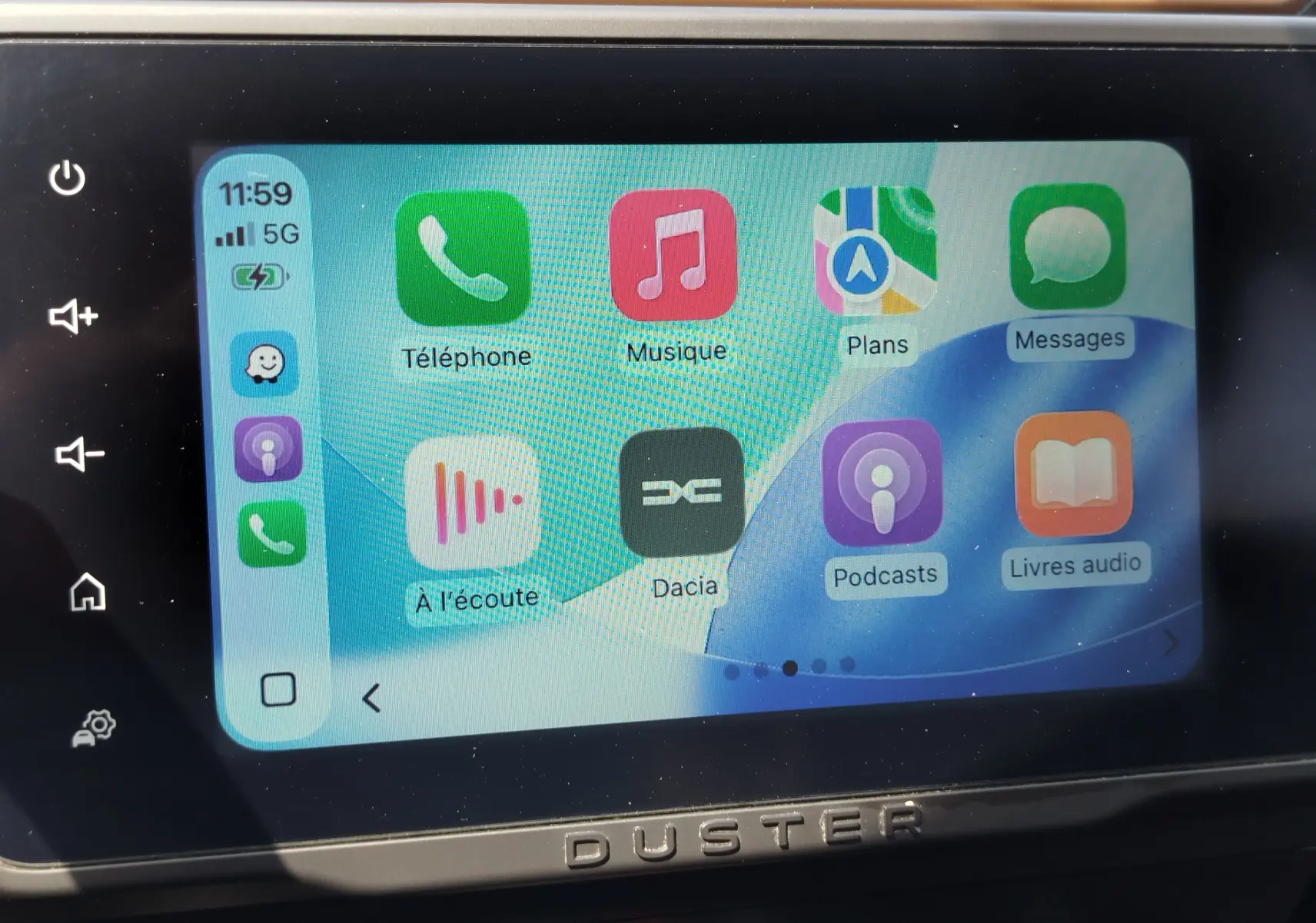 Écran tactile central du Dacia Duster 2024 affichant l'interface Apple CarPlay avec icônes colorées.