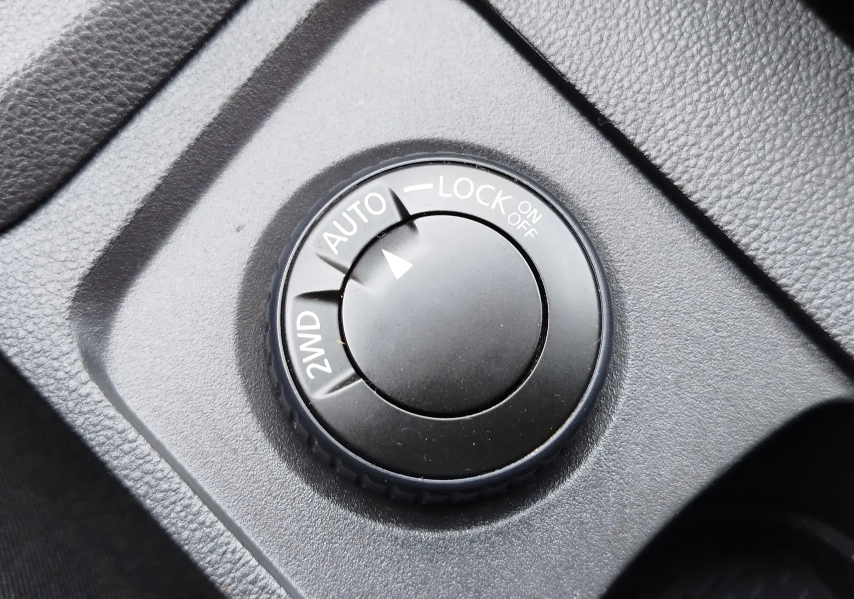 Gros plan sur le sélecteur de mode 4x4 du Dacia Duster 2024, avec options 2WD, Auto et Lock visibles.