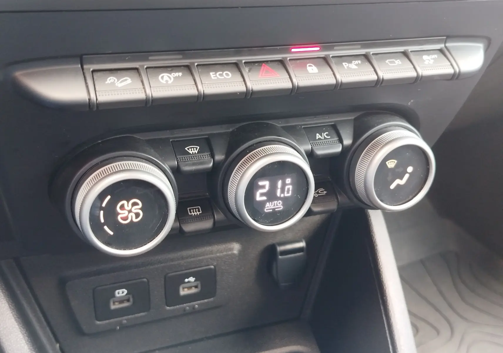 Gros plan sur la console centrale du Dacia Duster 2024, montrant les commandes de climatisation et les boutons de fonction.