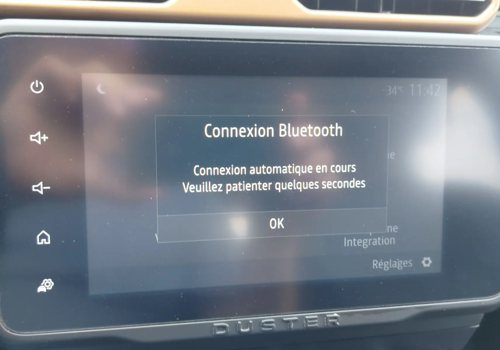 Écran tactile central du Dacia Duster 2024 affichant une connexion Bluetooth en cours, avec logo Duster en bas.