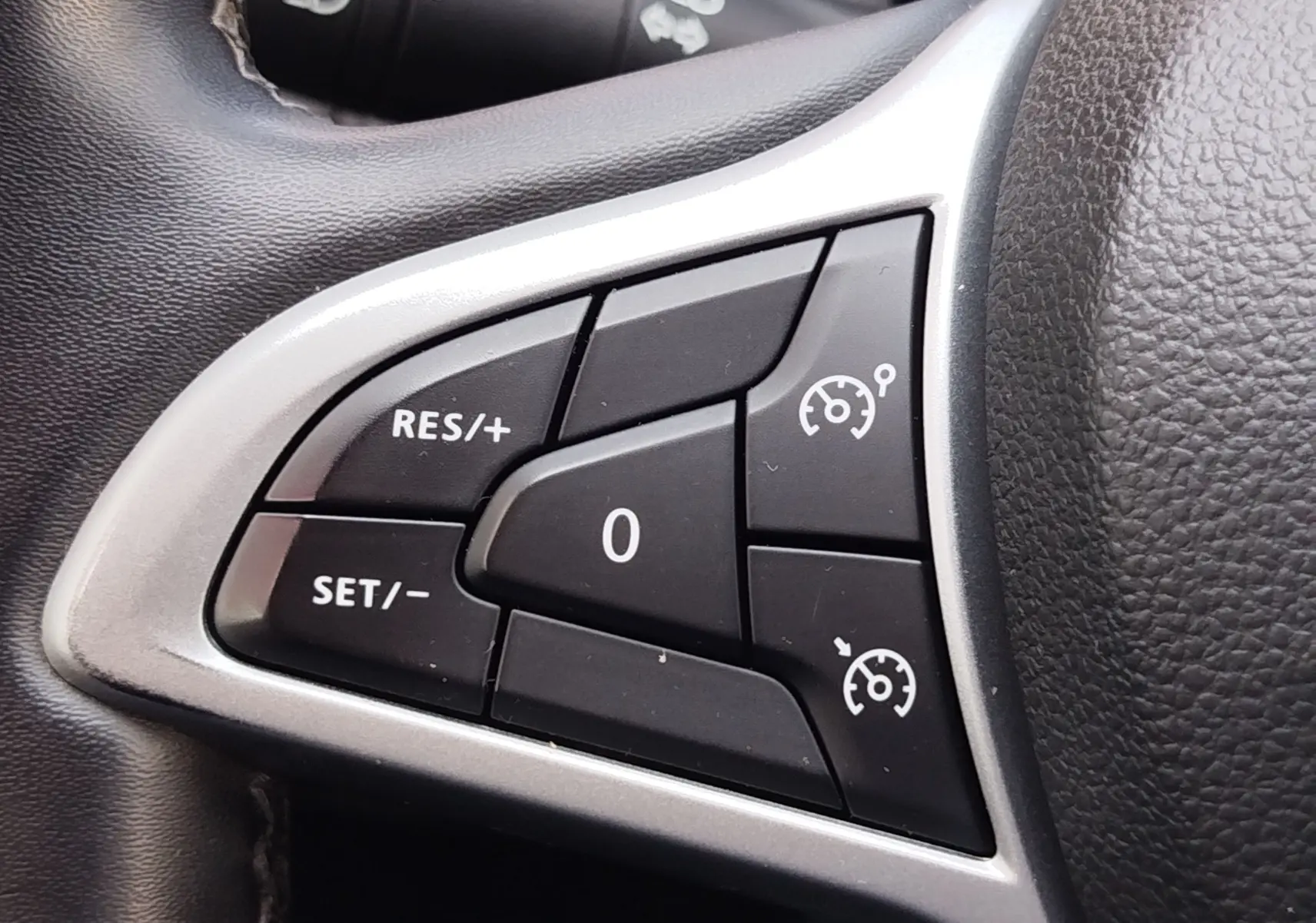 Gros plan sur les commandes de régulateur de vitesse au volant d’un Dacia Duster 2024, finition Extreme.