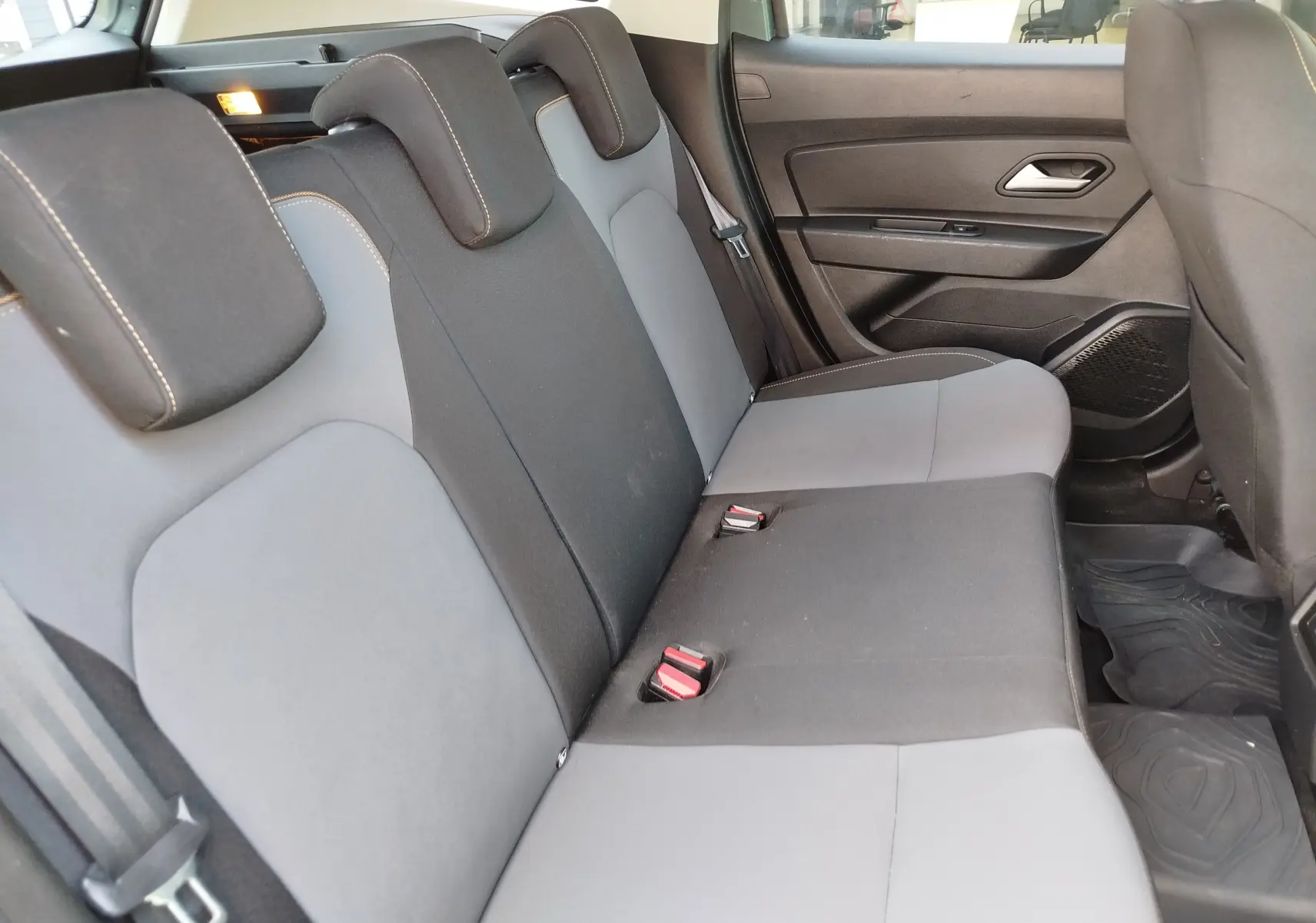 Vue intérieure côté droit des sièges arrière bicolores gris et noir du Dacia Duster 2024, version 1.5 Blue dCi Extreme 4x4.