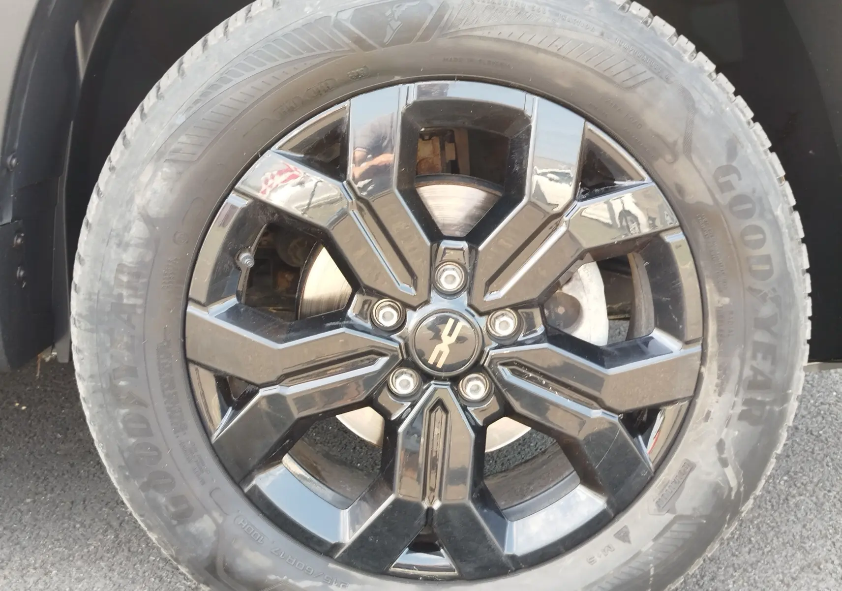 Gros plan sur la jante noire brillante du Dacia Duster 2024, avec pneu Goodyear et logo Extreme au centre.