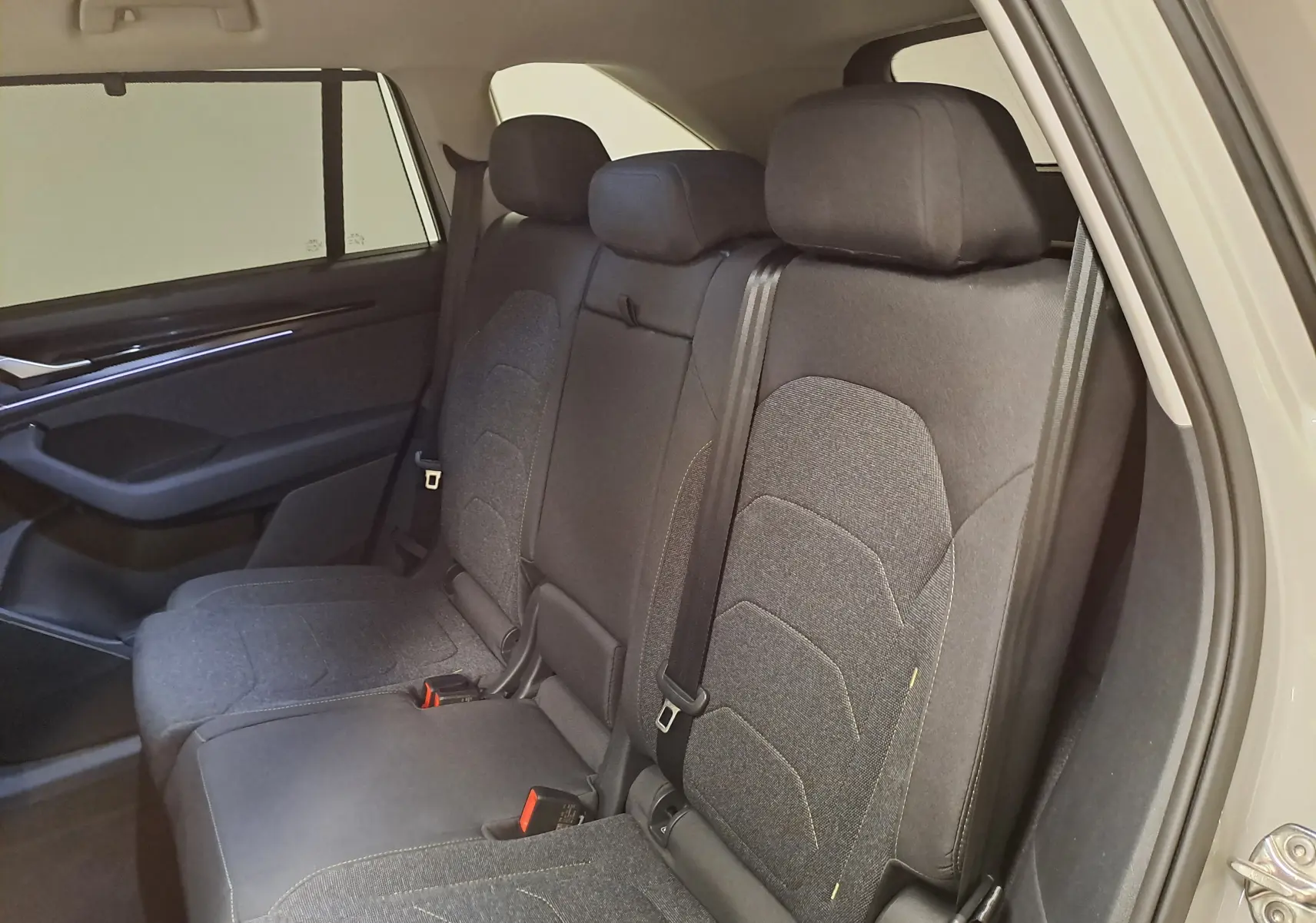 Vue intérieure côté droit des sièges arrière en tissu gris foncé du Skoda Kodiaq 1.5 Hybrid TSI 2025.