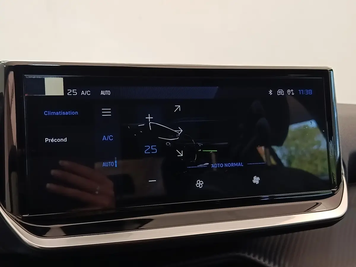 Écran tactile central affichant la climatisation automatique à 25°C dans une Peugeot 208 électrique blanche de 2024.