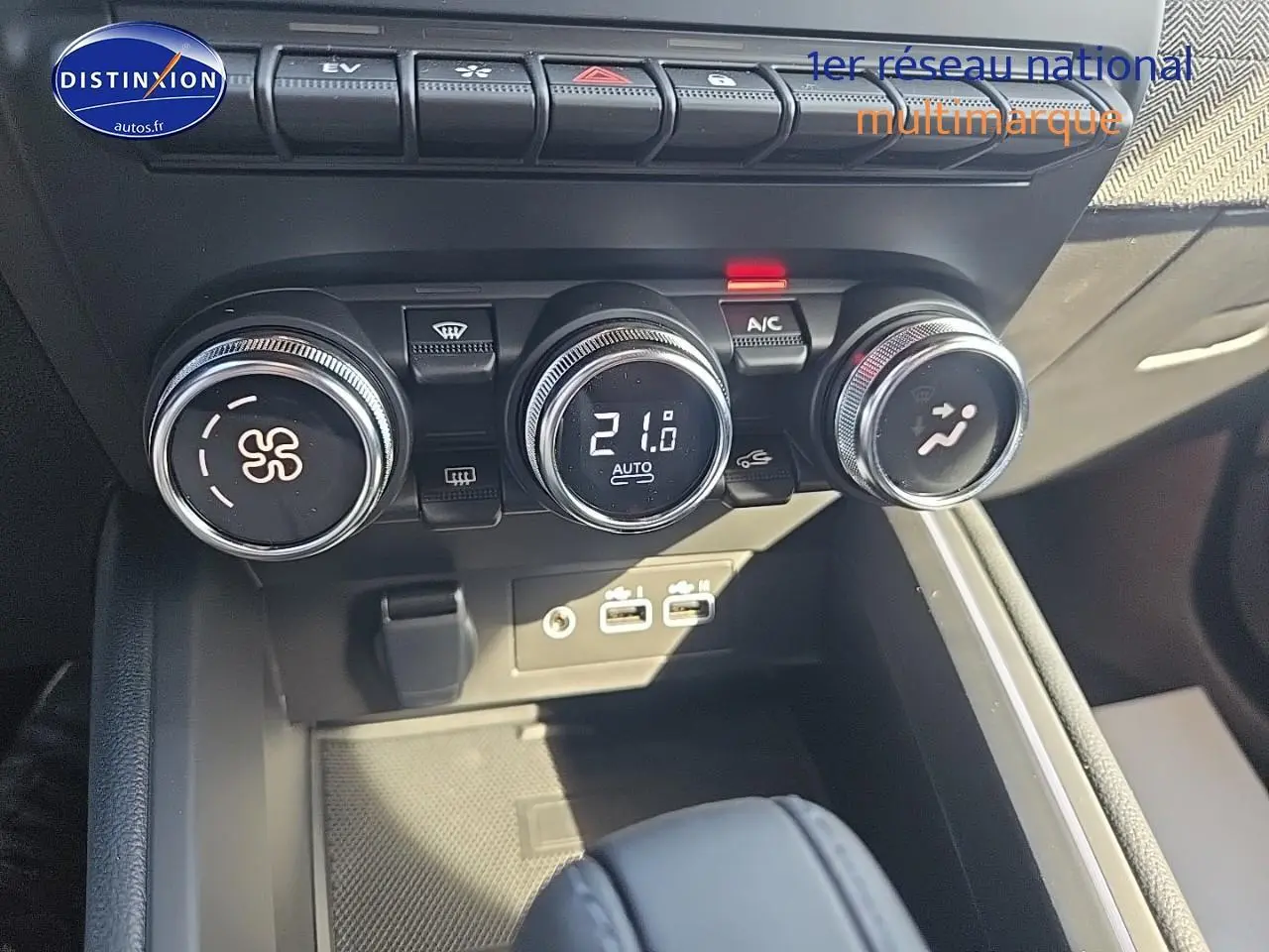 Détail des commandes de climatisation digitale et boutons multifonctions sur la console centrale d'une Renault Clio V.