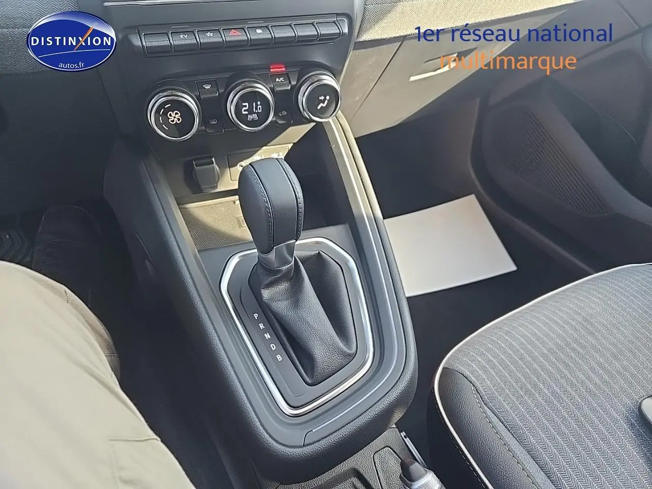 Vue rapprochée de la console centrale avec levier de boîte automatique et commandes climatisation d'une Renault Clio V bleu iron.