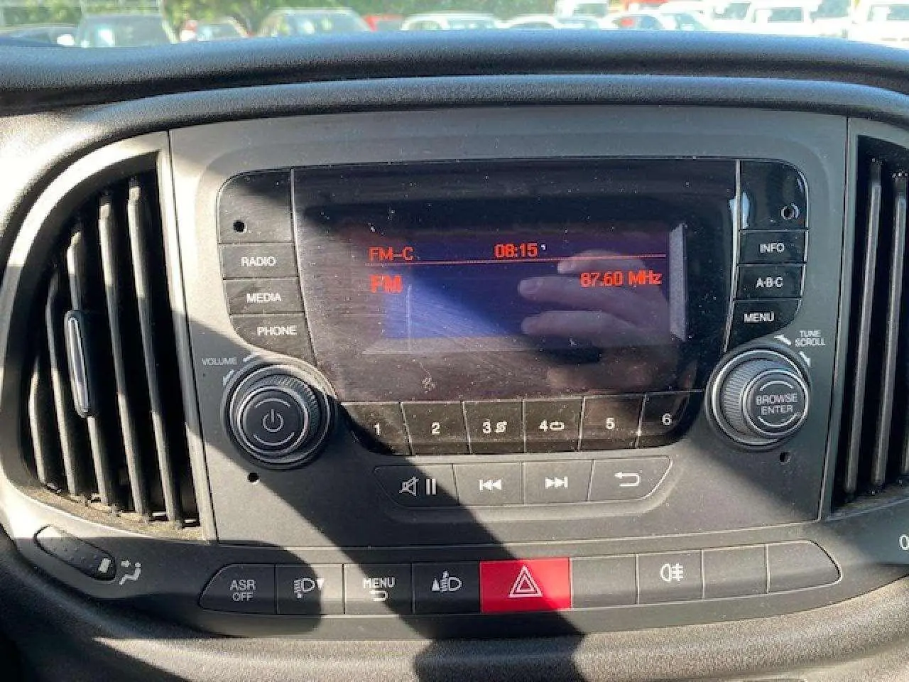 Vue rapprochée du tableau de bord du Fiat Doblo 2017 avec autoradio et commandes climatisation visibles.