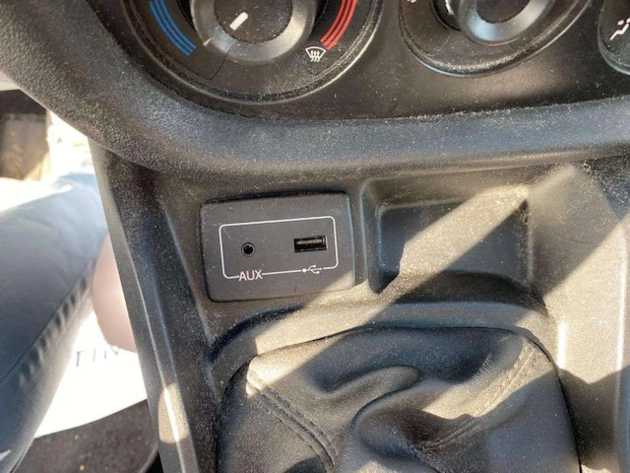 Vue rapprochée de la console centrale du Fiat Doblo 2017 montrant la prise AUX et USB près du levier de vitesses.