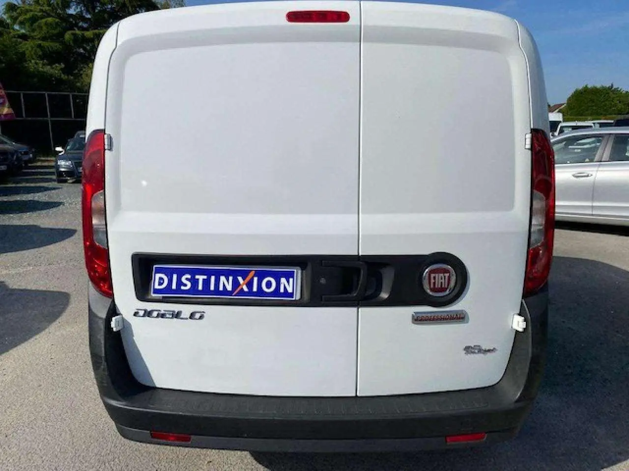 Vue arrière d'un fourgon blanc Fiat Doblo 2017 avec portes tôlées et logo FIAT visible au centre.