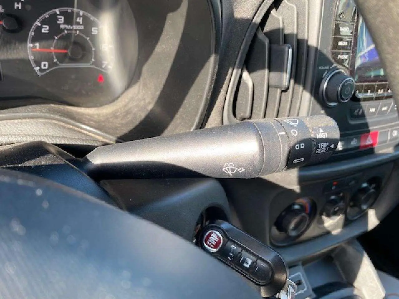 Gros plan sur la manette d'essuie-glace et la clé FIAT dans l'habitacle du Fiat Doblo blanc de 2017.