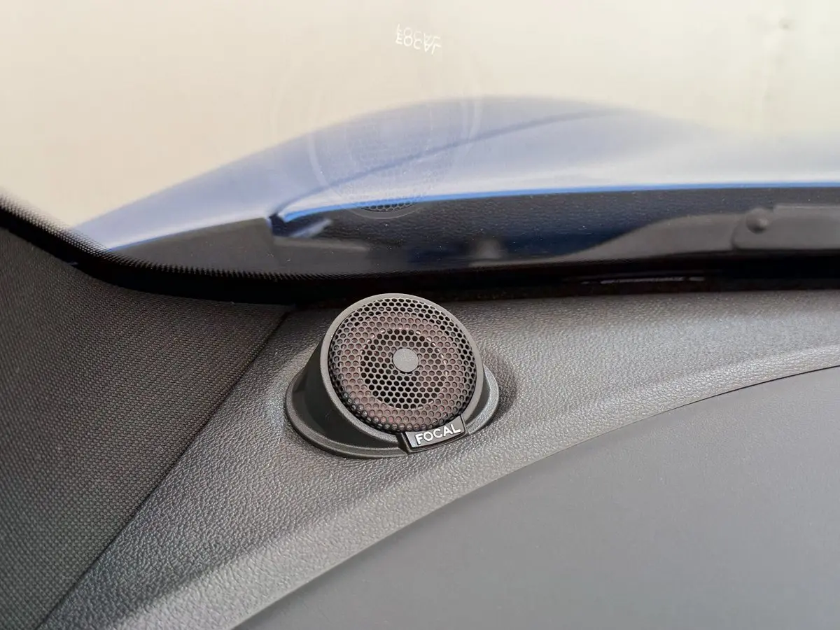 Gros plan sur le haut-parleur Focal intégré au tableau de bord d'une Alpine A110 Legende bleu, côté gauche.